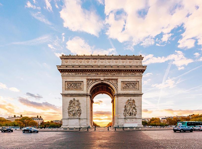 Arc de Triomphe at sunrise with traffic in Paris, France