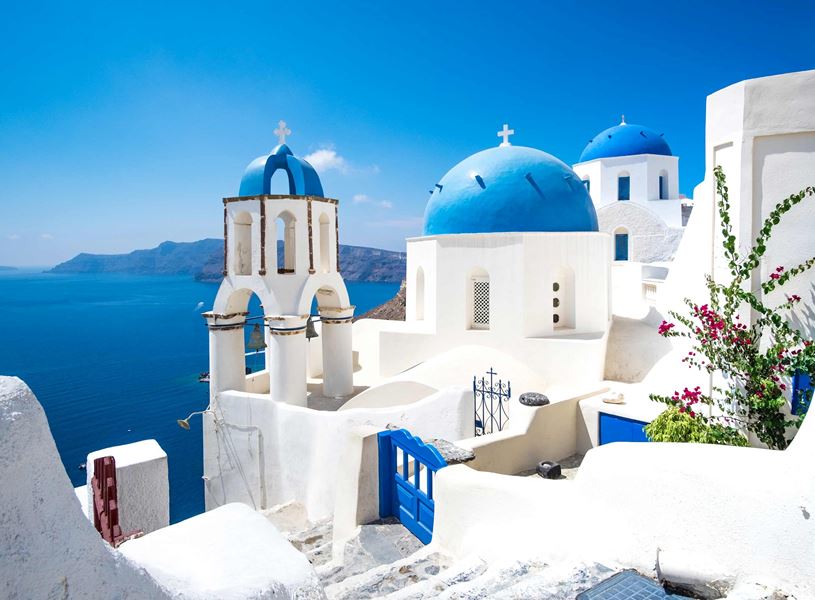 Whitewashed buildings with blue domes overlooking Aegean Sea, Santorini, Greece