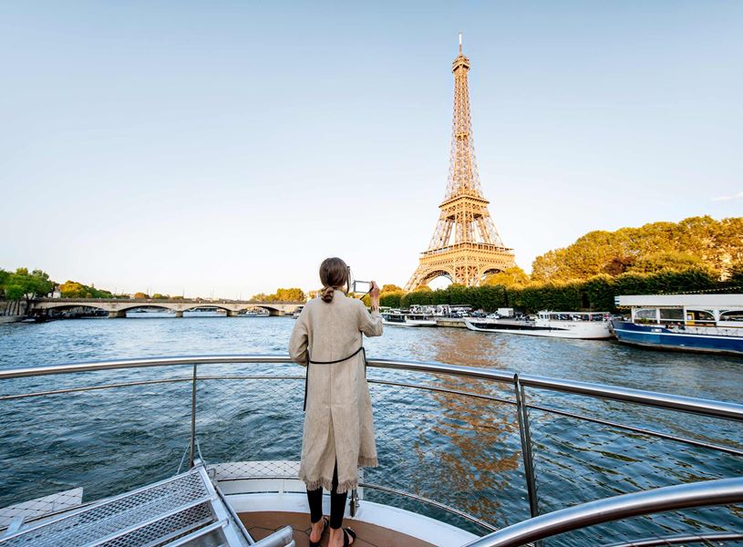 A person on a boat against the Eiffel Tower on a sunny day in Paris, France