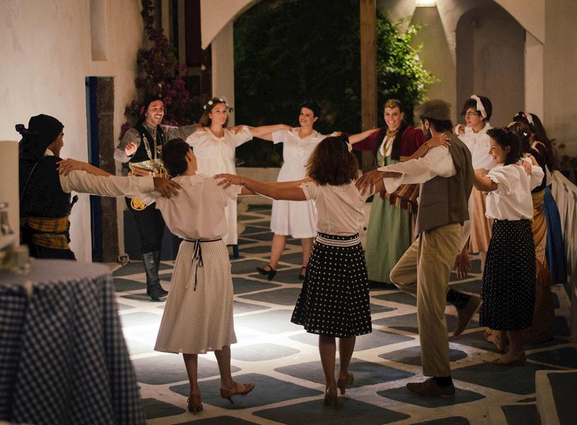 Group of people dancing in a circle during a Greek celebration