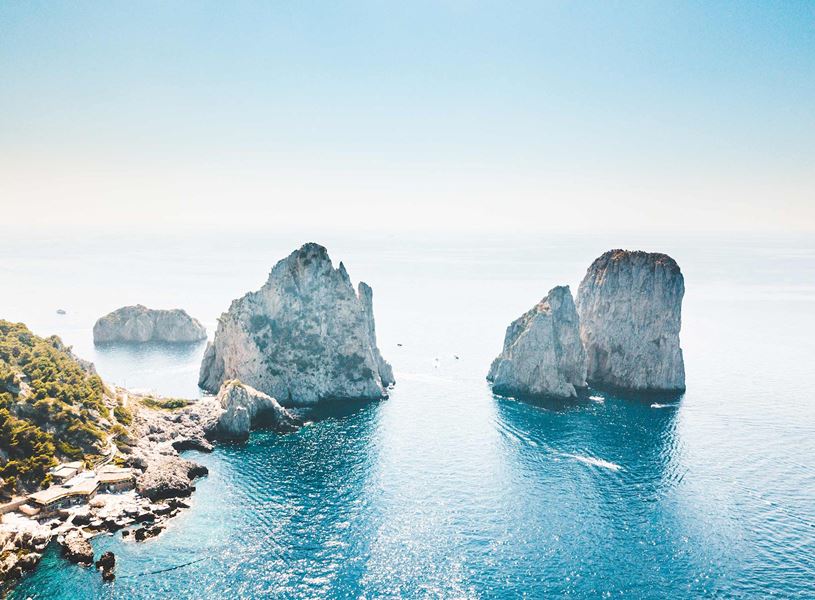 Faraglioni rock formations rising from turquoise waters off Capri coastline