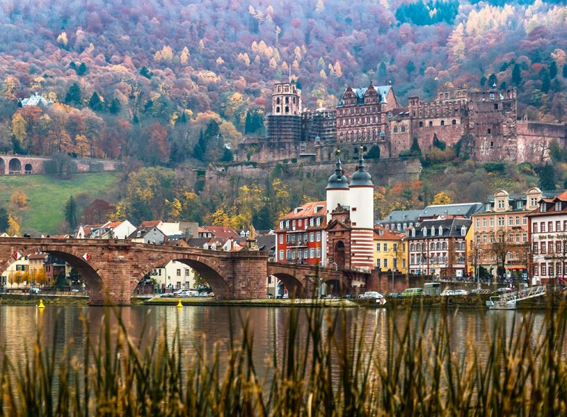 Heidelberg Castle above the Karl Theodor Bridge and town with autumn hillside