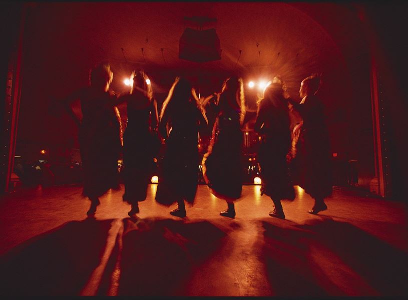Silhouetted dancers performing on warmly lit stage
